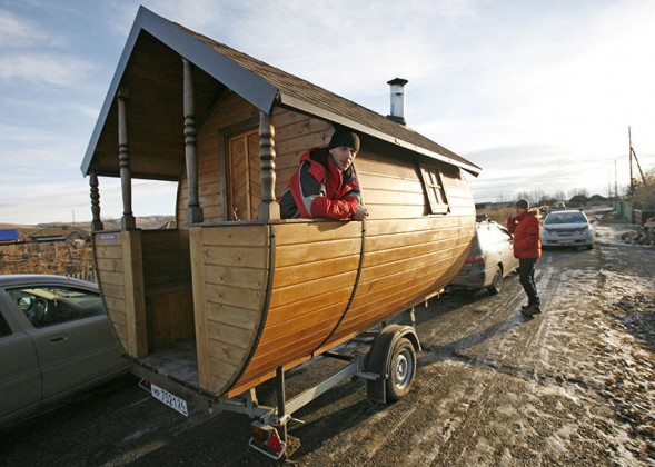 Valentine Krasin stands on his home-made mobile wooden Russian banya as he waits for friends in the village of Shoshino, about 455 km southeast of Russia's Siberian city of Krasnoyarsk, December 1, 2013. Krasin designed and constructed the mobile bathing station based on a traditional Russian banya or steam bath, intending it for trips with friends and possibly as a small commercial venture. Picture taken December 1, 2013.  REUTERS/Ilya Naymushin (RUSSIA - Tags: SOCIETY HEALTH) - RTX160UP
